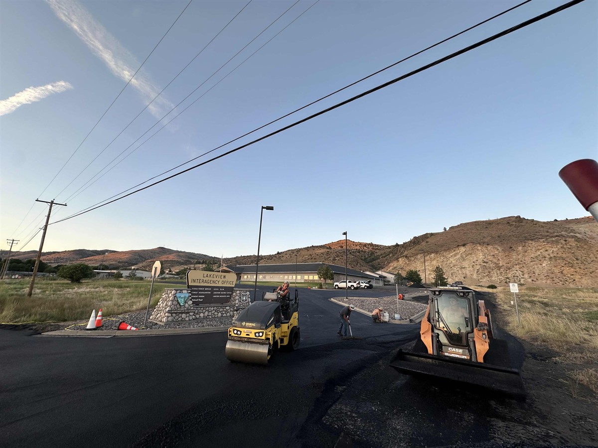 Asphalt paving crew and equipment preparing a job site