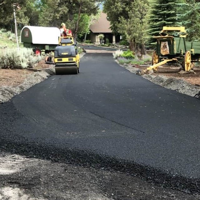 Roller compacting a new asphalt driveway in Bend Oregon
